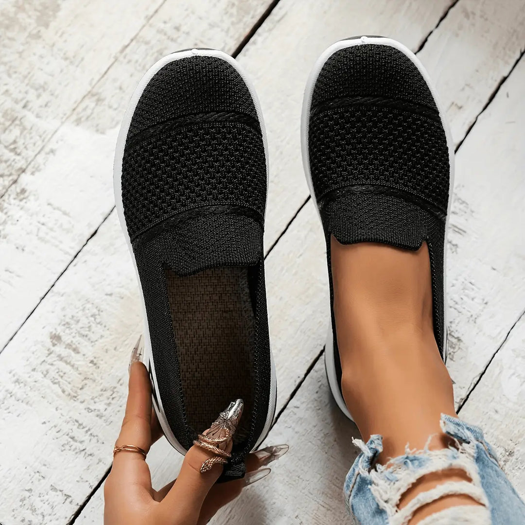 Zapatillas livianas negras para mujer con diseño transpirable de malla, suela blanca antideslizante para mayor comodidad y soporte, ideales para uso diario, caminar y actividades casuales, calzado flexible y ergonómico que ofrece confort durante todo el día.