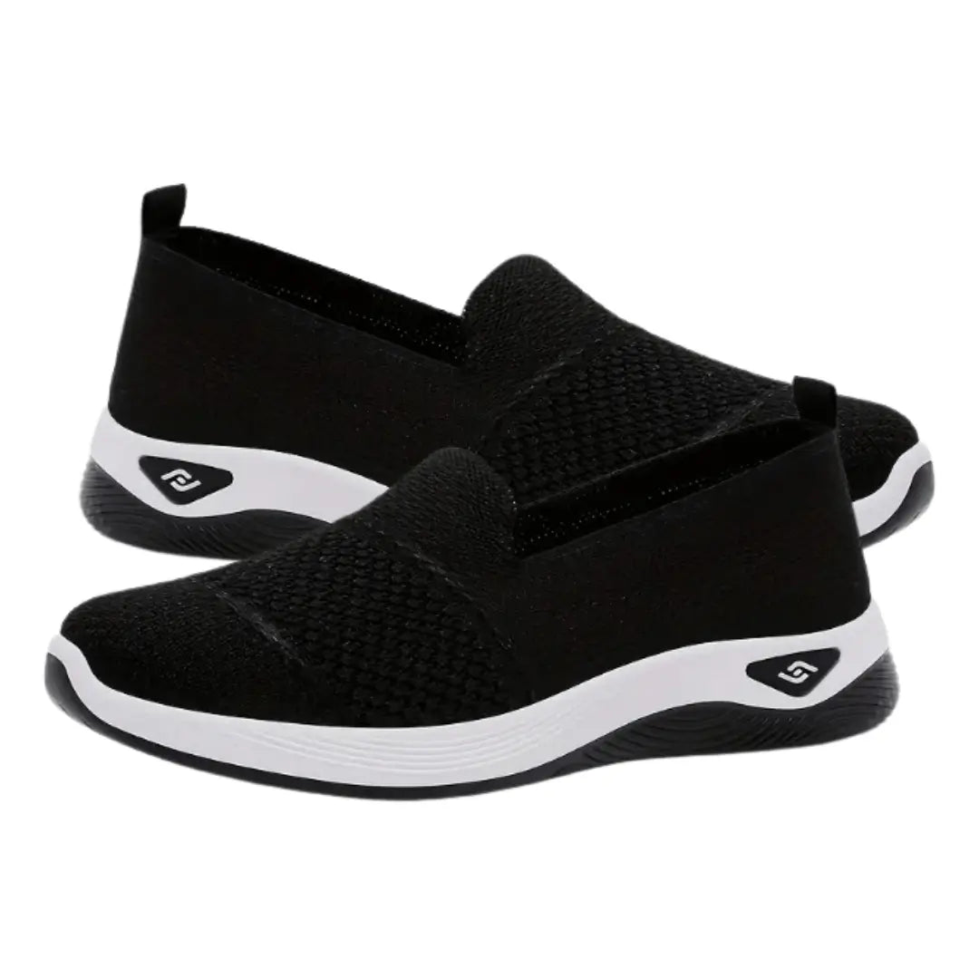 Zapatillas deportivas livianas color negro con diseño transpirable en tejido mesh, suela antideslizante blanca y negra, calzado cómodo ideal para uso diario, fácil de poner gracias a su ajuste slip-on, perfectas para caminar y actividades casuales manteniendo frescura y soporte en los pies.