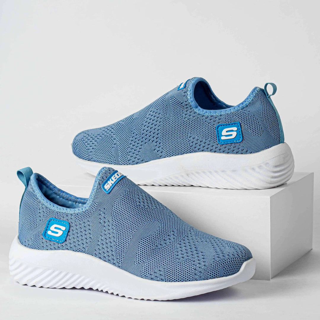 Zapatillas deportivas azul claro para mujer, diseño slip-on con tejido transpirable y suela blanca antideslizante con amortiguación ligera para máximo confort y flexibilidad, ideales para uso diario y caminatas largas en Colombia.
