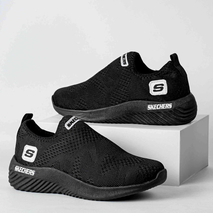 Zapatillas Comfy Flex negras para hombres y mujeres, diseño slip-on sin cordones con tejido transpirable, suela ligera y flexible con amortiguación máxima para comodidad todo el día, ideales para uso casual, caminar y ejercicio, calzado deportivo colombiano de alta durabilidad y estilo moderno.