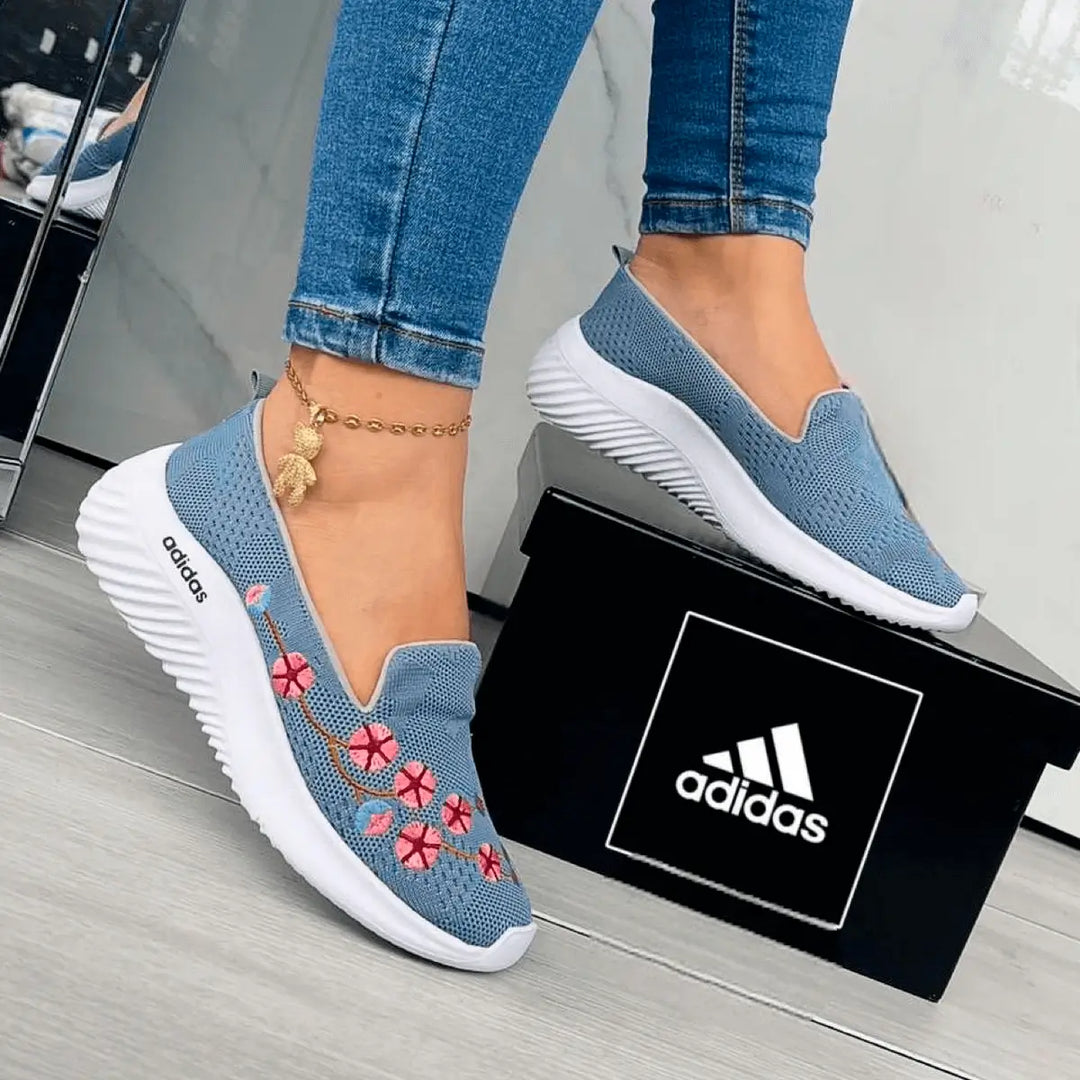 Zapatillas florales para mujer en color azul con bordados de flores rosas, diseño cómodo y ligero ideal para uso diario, suela blanca antideslizante para mayor seguridad, perfectas para combinar con jeans y outfits casuales, calzado transpirable y flexible que ofrece confort y estilo moderno.