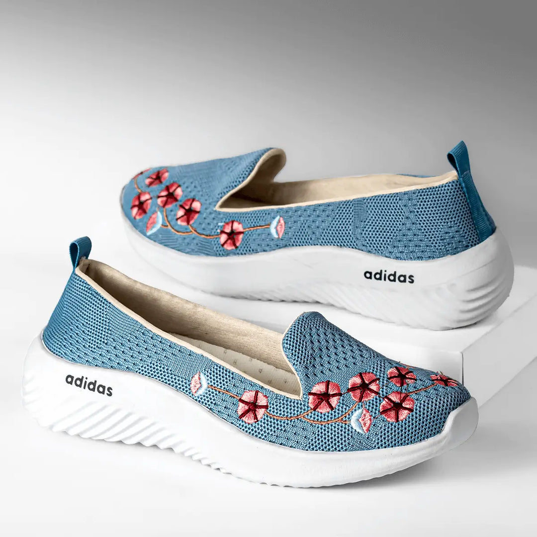 Zapatillas femeninas color azul con bordado floral rojo, diseño cómodo y transpirable de malla knit, suela blanca antideslizante y ligera, ideal para uso diario, moda casual y estilo urbano, perfectas para mujer que busca confort y estilo en calzado deportivo.