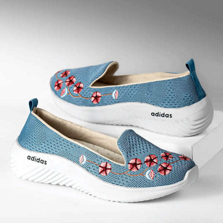 Zapatillas femeninas color azul con bordado floral rojo, diseño cómodo y transpirable de malla knit, suela blanca antideslizante y ligera, ideal para uso diario, moda casual y estilo urbano, perfectas para mujer que busca confort y estilo en calzado deportivo.