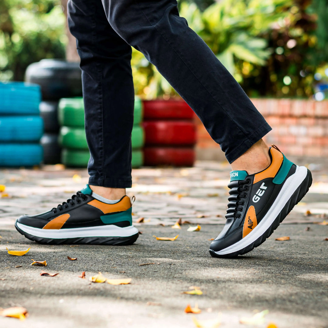 Zapatillas deportivas negras con detalles en naranja y verde, suela blanca y negra antideslizante, diseño moderno y cómodo para uso diario, perfectas para caminar y actividades urbanas, calzado ligero y resistente ideal para hombre.