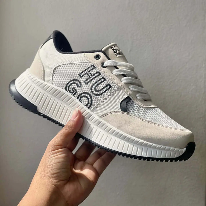 Zapatilla deportiva blanca con detalles negros, diseño moderno con suela antiderrapante y espuma de alta comodidad, ideal para uso diario y actividades casuales, ligera y transpirable para mayor frescura y soporte en cada paso.