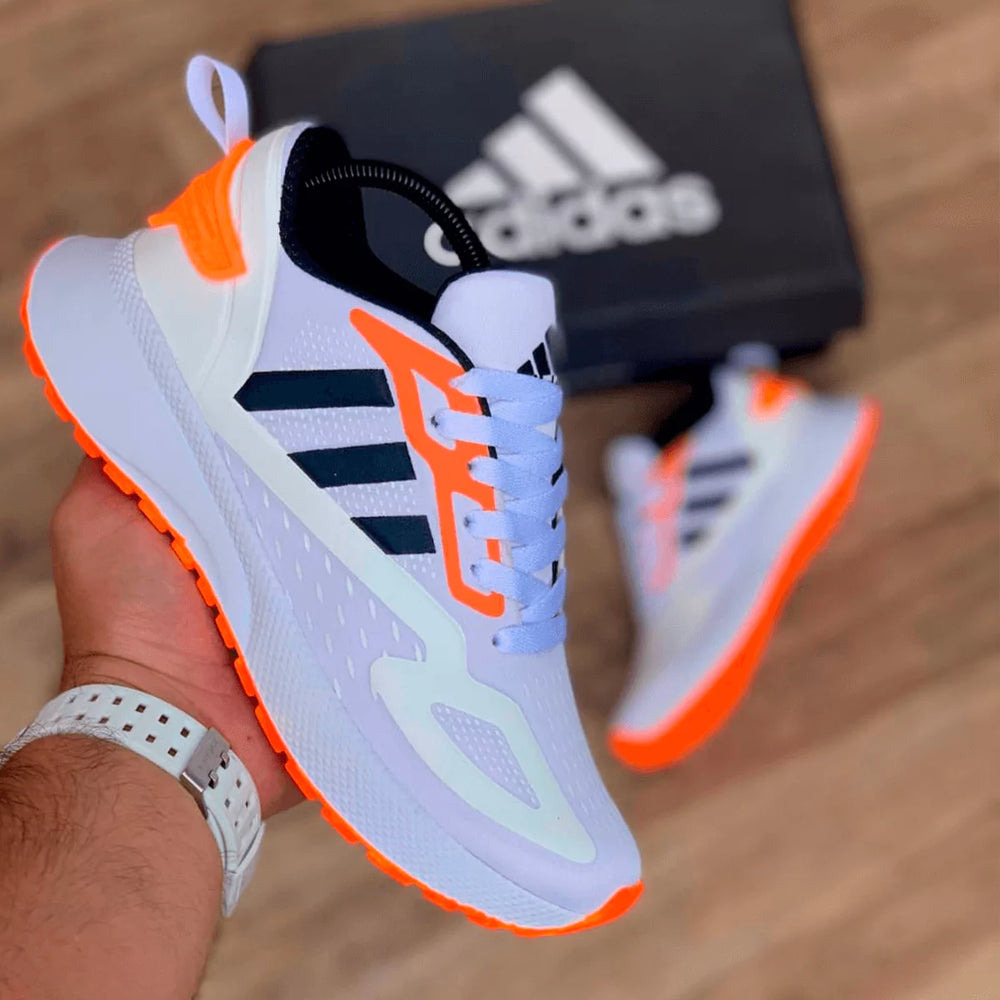 zapatillas blancas con toques en color naranja, modelo enérgico y deportivo para actividades al aire libre.