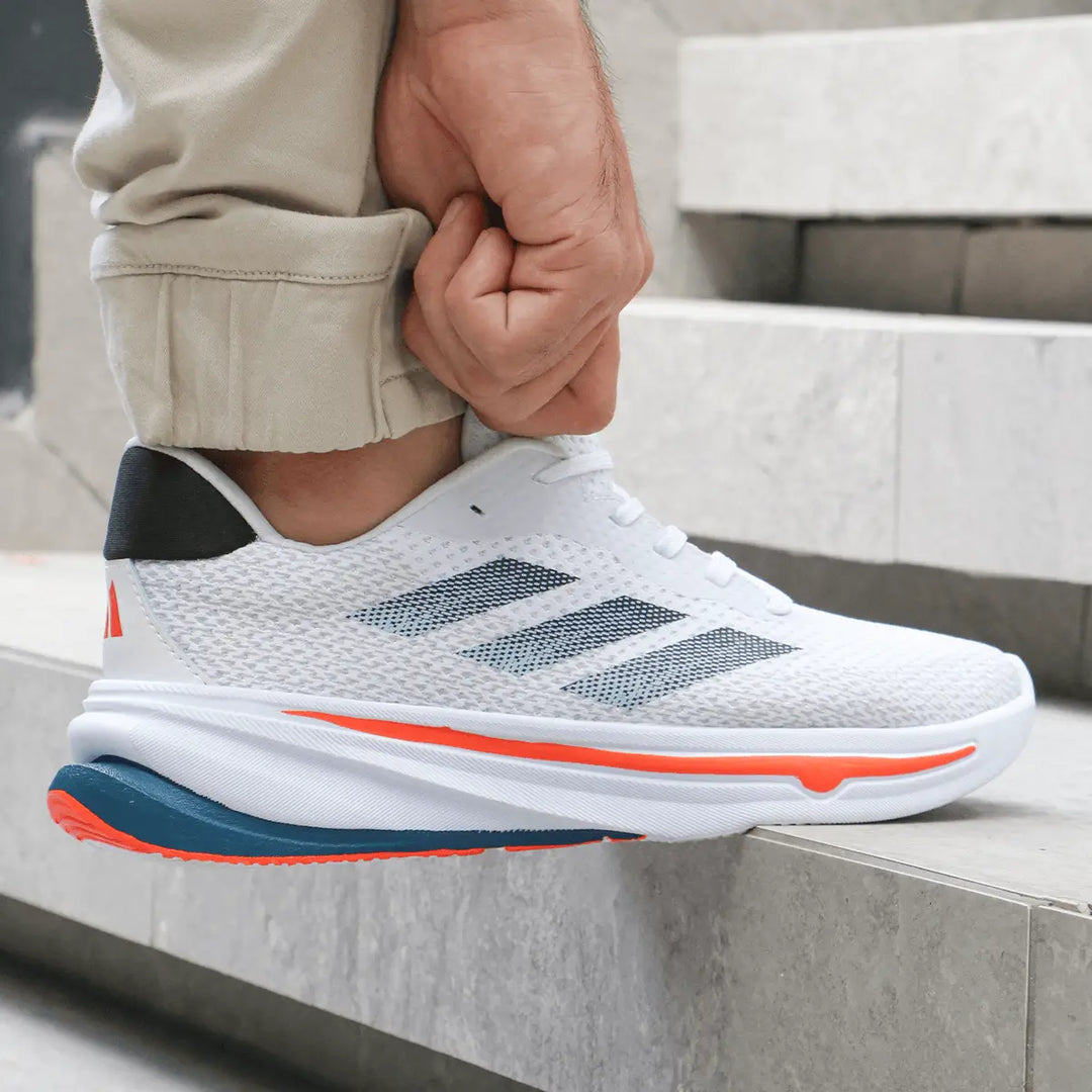 Zapatillas blancas para correr con diseño moderno y detalles en azul y naranja, suela antideslizante y ligera, materiales transpirables para máximo confort y soporte ideal para ejercicios y uso diario.