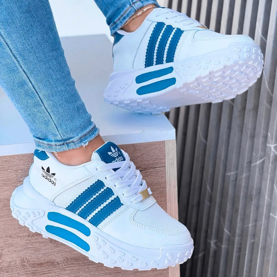 Zapatillas tractor blancas con detalles en azul, suela gruesa antideslizante para mayor seguridad, diseño deportivo y moderno ideal para uso urbano y casual, cómodas y resistentes perfectas para caminar todo el día.